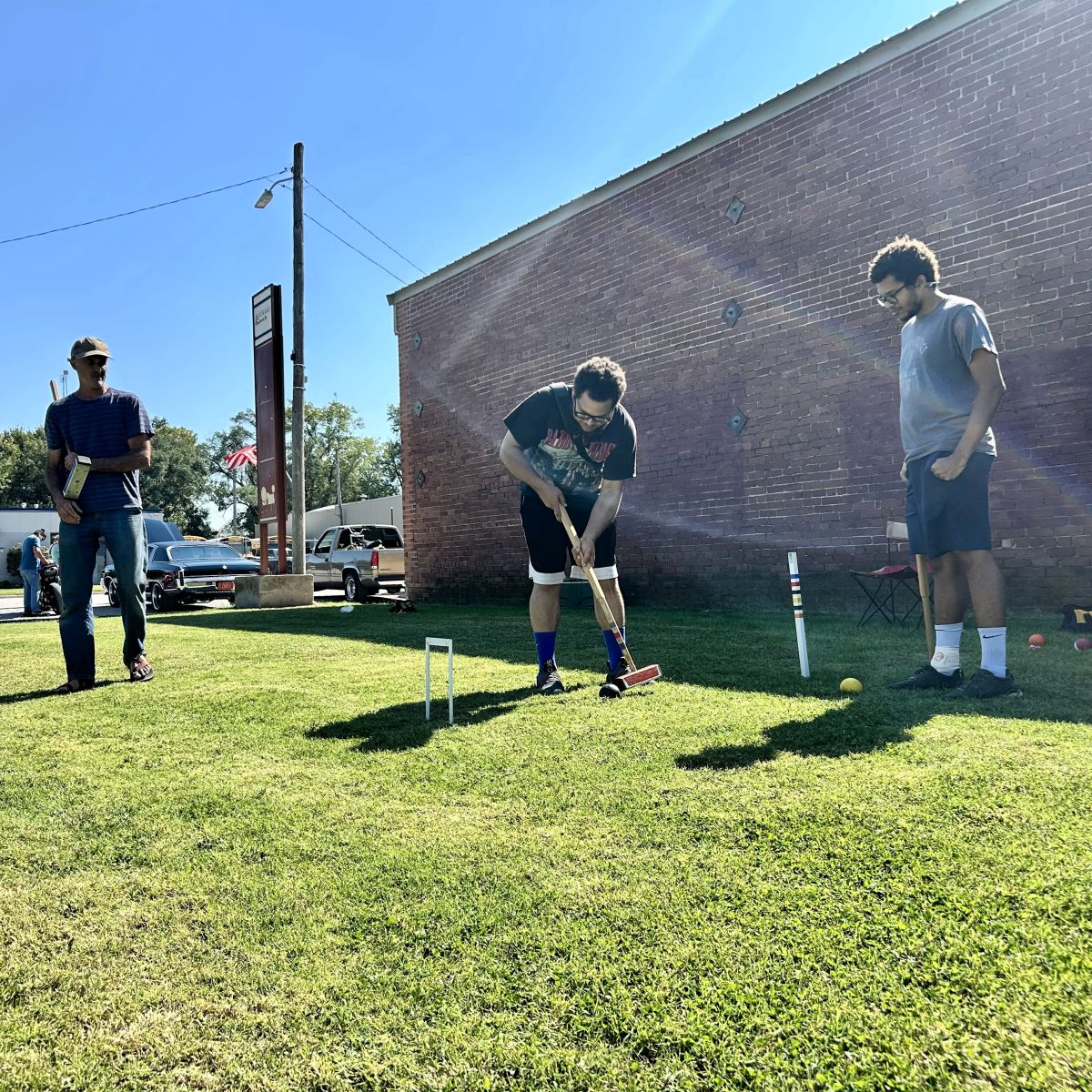 a group of gentlemen playing croquet