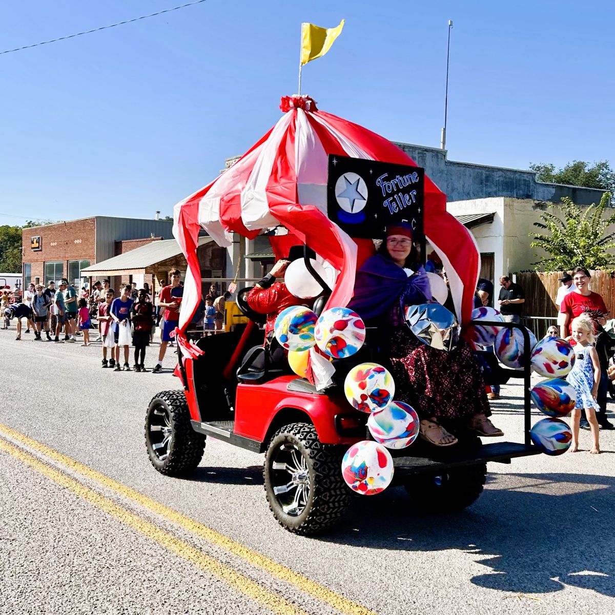 another golf cart decorated for the circus theme with a fortune teller riding on the back seat