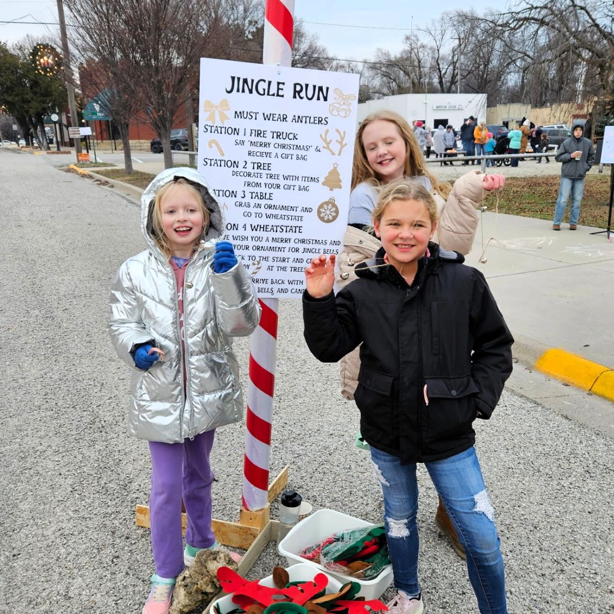 three girls at the jingle run rules sign
