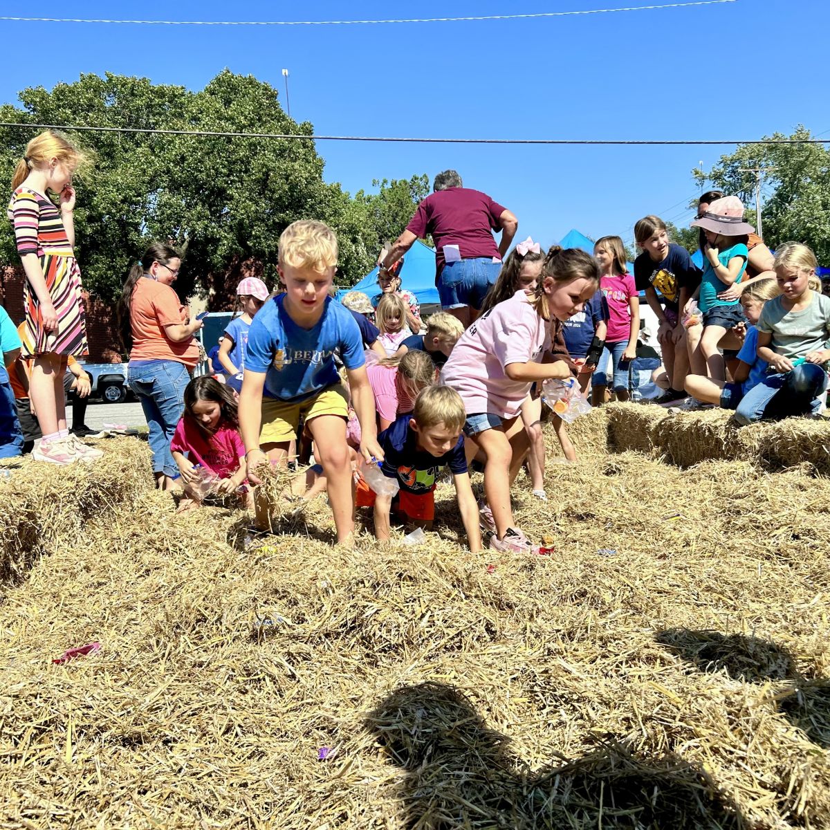Kids hunting through hay to find money