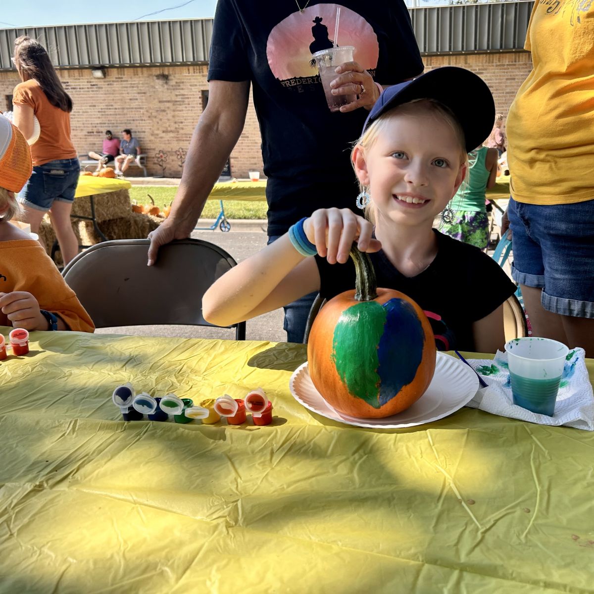 smiling child with her painted pumpkin